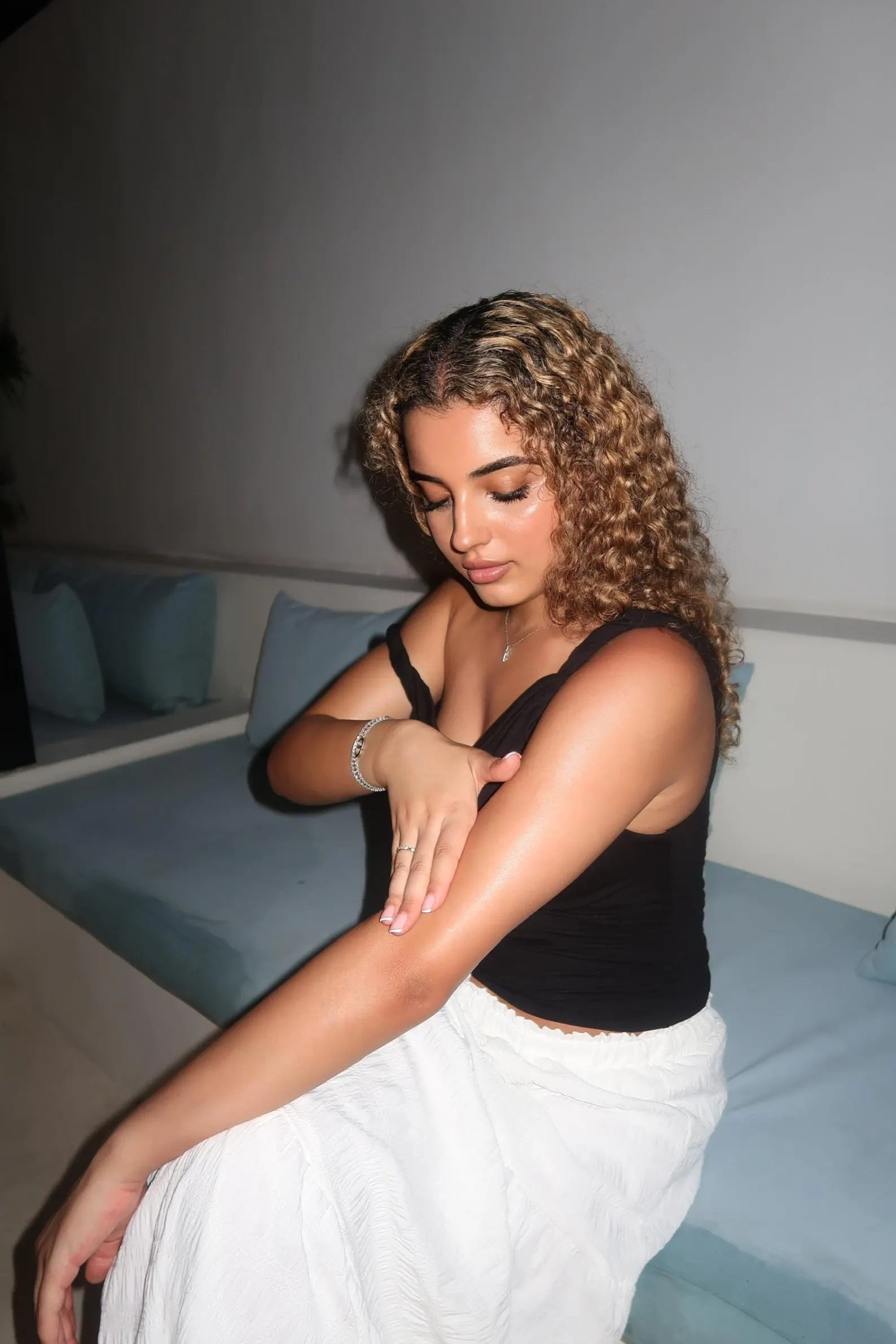 Woman sitting on a couch with a neutral background